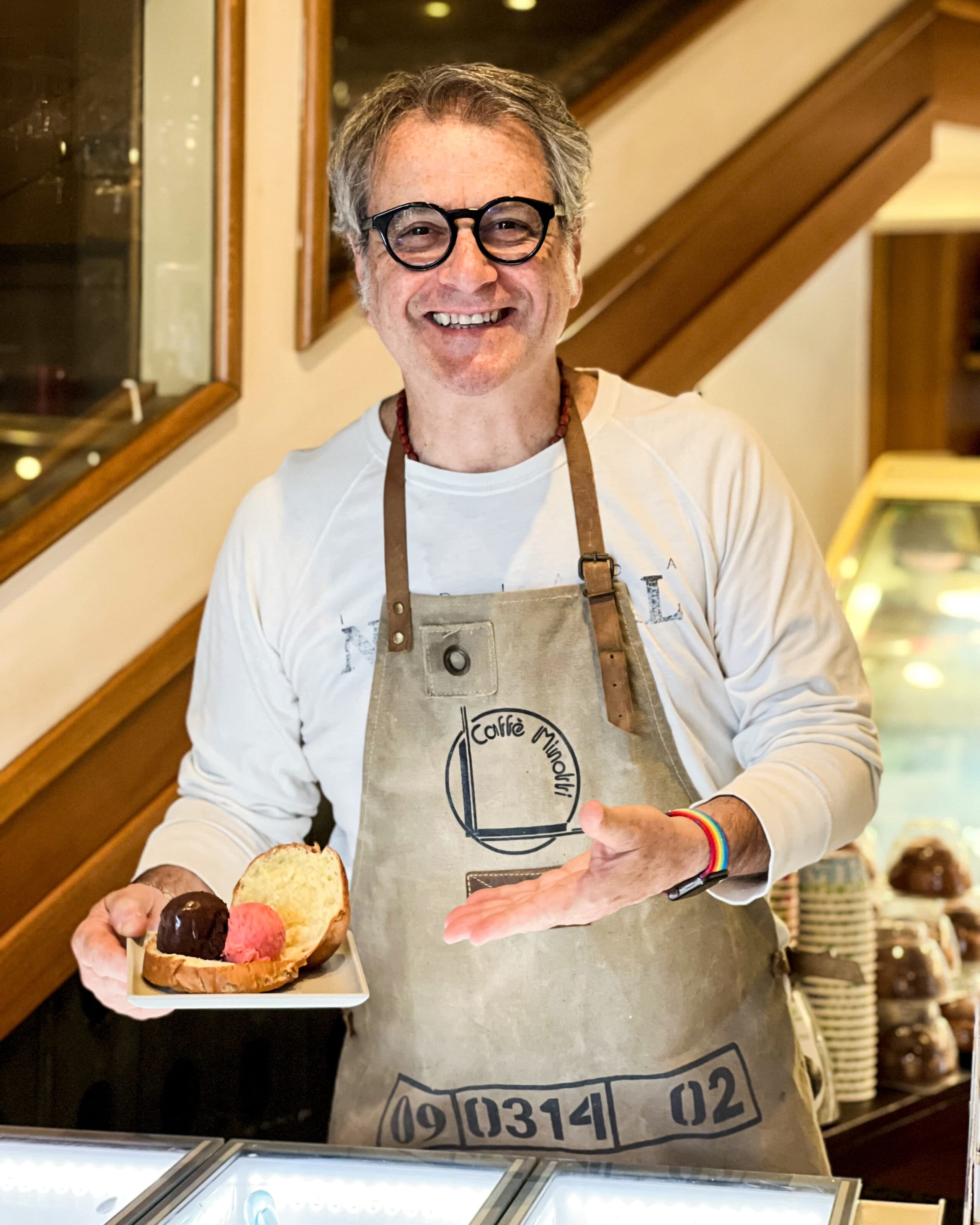 Vincenzo Minotti con il grembiule del Caffè Minotti e una brioche con il gelato